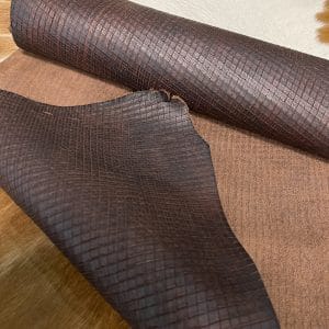 Introducing Alexa Veg Tanned Cow Leather - a special type of leather that is crafted from full grain hide and treated with vegetal tanning. This unique leather boasts a reptile scale-like appearance, but with a more polished and refined look. An aniline finish gives it a waxy, matte texture, while deep grooves outline each square, highlighting their appearance. The squares are also creased, adding texture and definition. The Alexa collection is perfect for various leather needs due to its subtle shine and remarkable design. This leather is made from heifer (double shoulder) and weighs 5/6 oz. (2.2 mm-2.4 mm). It is 100% veg-tanned and dyed through (drum dye). The leather is classified as full-grain with a medium pull-up, has a semi-soft temper, and is sourced from Mexico. The Alexa leather is perfect for crafting straps, handbags, accessories, footwear, belts, and leather crafts.