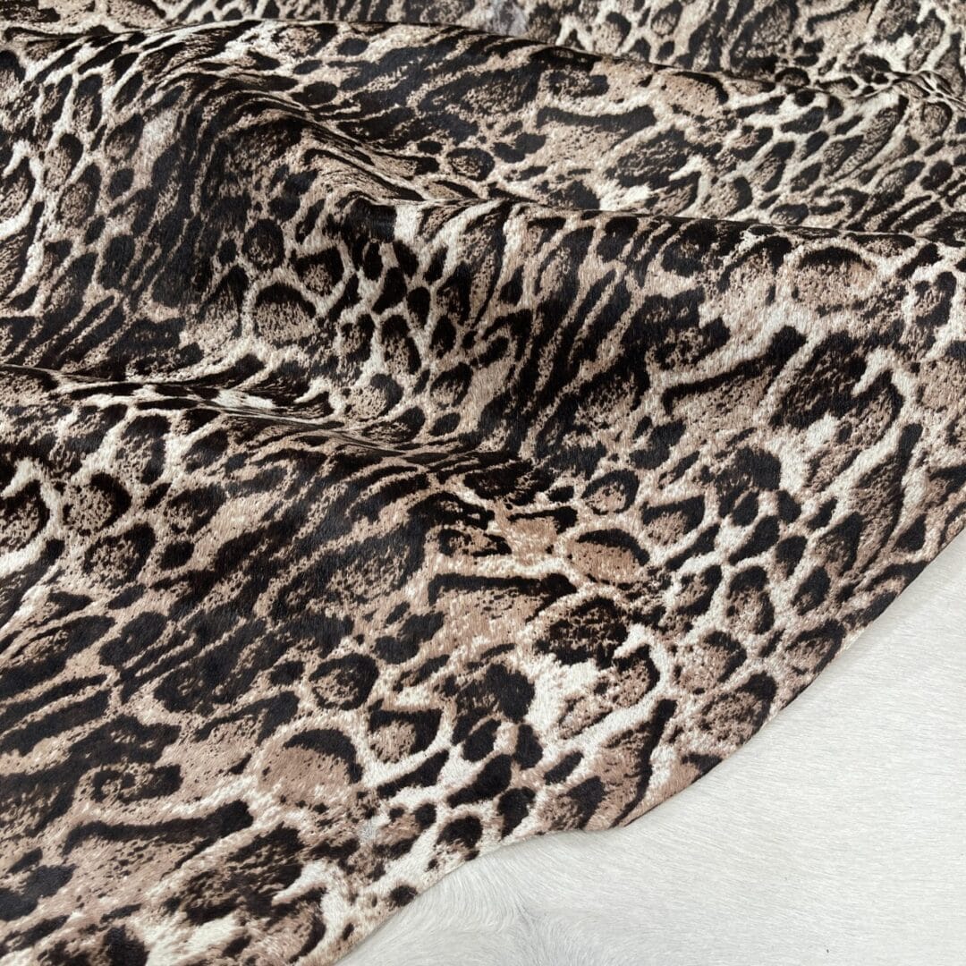 Panther-Gray This beige cowhide with panther print adds a fierce, fashion-forward edge to any design. With bold black markings over soft beige tones, it's ideal for handbags, shoes, garments, furniture, pillows, and interior décor. Printed on premium hair-on cowhide and chrome tanned for durability and softness. Each hide is unique, perfect for custom statement pieces.