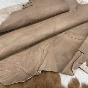 SL-209TAU Taupe Goat 2 The Goatskin-washed Leather Collection offers an exclusive range of leather that undergoes a special tanning process, resulting in a unique and irregular texture. The leather's shrunken grain creates a striking and dynamic appearance, while its distressed look adds to its appeal. The thickness of the leather adds to its durability and dependability. The collection features a variety of warm and distinct colors that make it ideal for creating timeless looks.