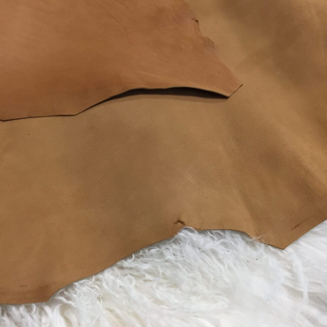 Doe (2) goat suede The Goatskin Suede Leather features a wonderful texture that is eye-catching and feels luxurious to the touch. Its versatility stems from a distinctive tanning method that involves gentle buffing, making it ideal for use in various items such as clothing, moccasins, lining, handbags, shoes, and accessories. Those who value timeless elegance and quality will undoubtedly find this leather worth the investment, as it guarantees utmost quality and worth through full hide pieces that typically range in size between 2-4 square feet and have a thickness of 3 oz (1.0-1.1mm). What is Goat Suede? Goat suede undergoes an extra finishing process that creates a velvety texture. This process involves buffing the flesh side of the hide, resulting in a soft and textured nap that feels wonderful to the touch.