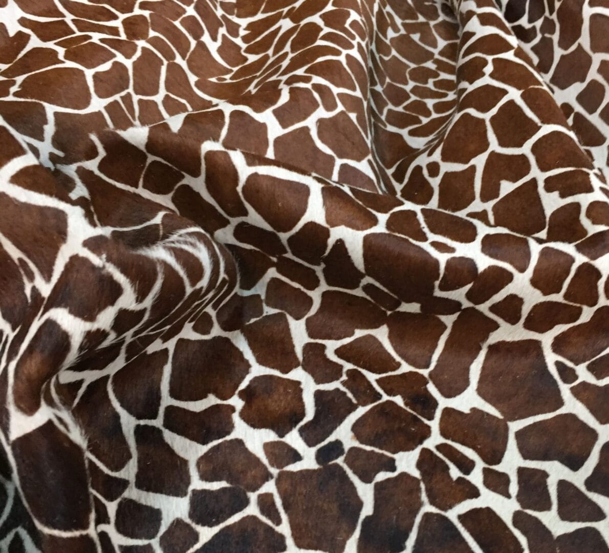 Cow Hair On Giraffe-Chestnut This chestnut cowhide features a bold giraffe print, offering a unique, exotic touch to any project. Perfect for handbags, upholstery, footwear, garments, pillows, and décor. Printed on premium hair-on cowhide for durability and natural texture with a wild, stylish edge. Each hide is one-of-a-kind—ideal for standout fashion and interior designs.
