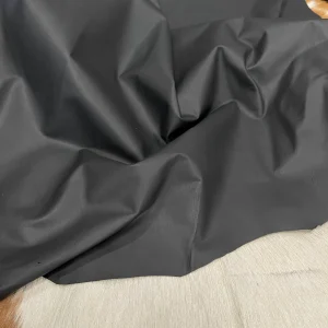 SL-100BLK Lambskin Leather Avetcoinc This high-quality lambskin garment leather is made from 100% British lambskin, renowned for its soft and supple texture. The leather is expertly tanned using the chrome tanning process, which results in a durable and long-lasting product that will wear beautifully over time. The leather is available in a full hide size of 5-7 sq. ft. and has a full-grain finish, which means that it retains the natural texture and markings of the original hide. The thickness of the leather is 1 oz, which equates to a range of 0.4-0.6 mm. The leather is sourced from Turkey, where it undergoes rigorous quality control procedures to ensure that it meets the highest standards. The resulting product is a premium-grade leather that is perfect for creating luxurious garments and accessories that will stand the test of time.