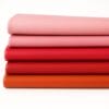 Milano-Reds Oranges and Pinks Collection Five rolls of Milano Collection smooth cowhide leather in red, orange, and pink tones, featuring natural grain and soft handfeel, laid on a white background.