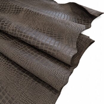 black olive escape alligo cow leather crocco belly embossed Rolled dark brown crocodile-embossed leather sheets with distinct scale pattern.