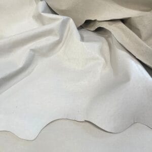 White fabric draped in soft folds with gentle shadows creating curves and texture.