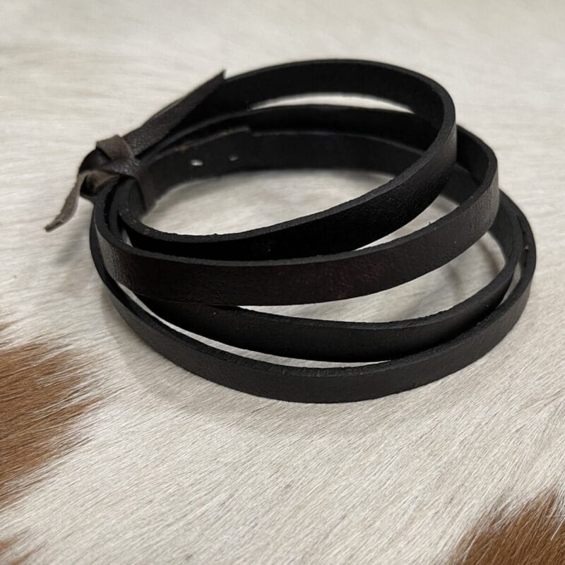 brown 8mm Black leather wrap bracelet with multiple slim bands coiled together on a light fur surface.