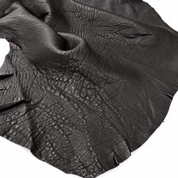 Close-up of black leather with pronounced grain and wrinkles, showing natural texture and folds