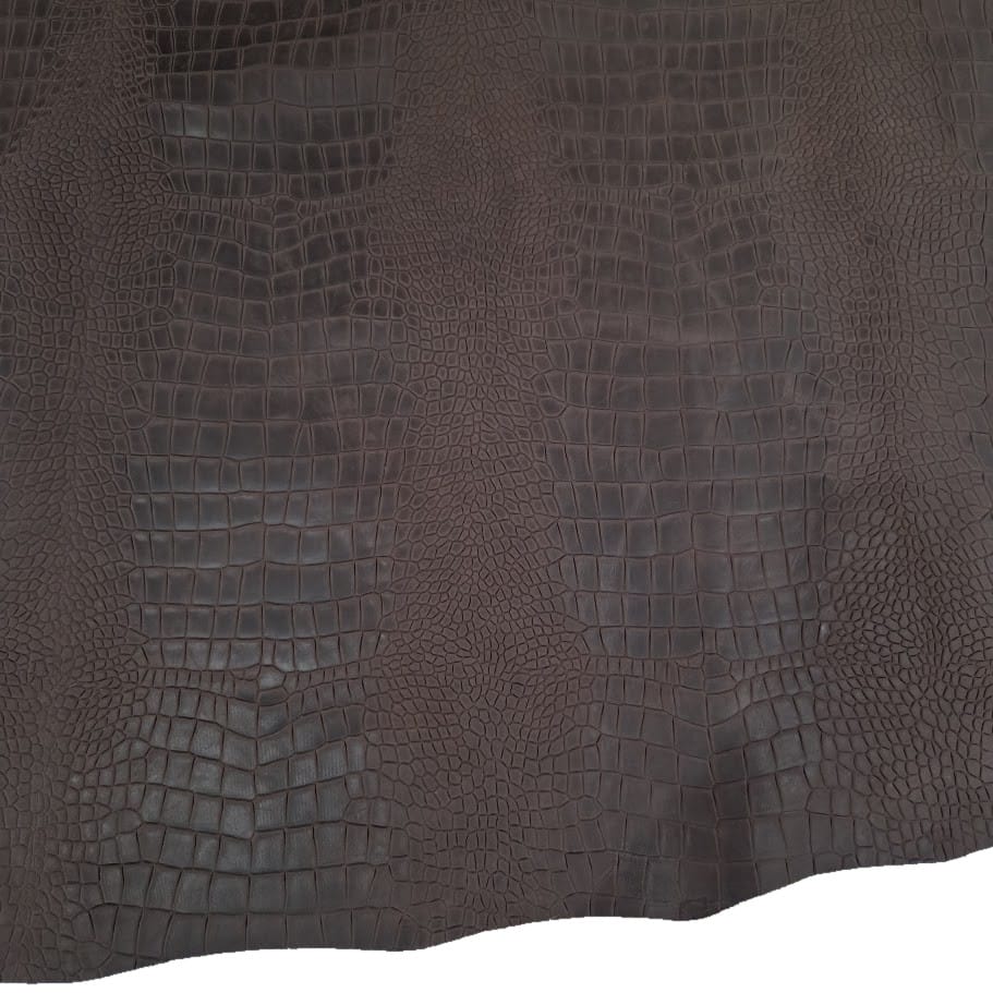 chocolate escape alligo cow leather crocco belly embossed close up Dark brown crocodile leather texture with raised scale pattern across the surface.