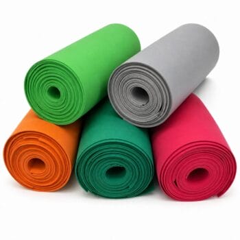 Stack of rolled yoga mats in green, gray, orange, teal, and pink forming a pyramid.