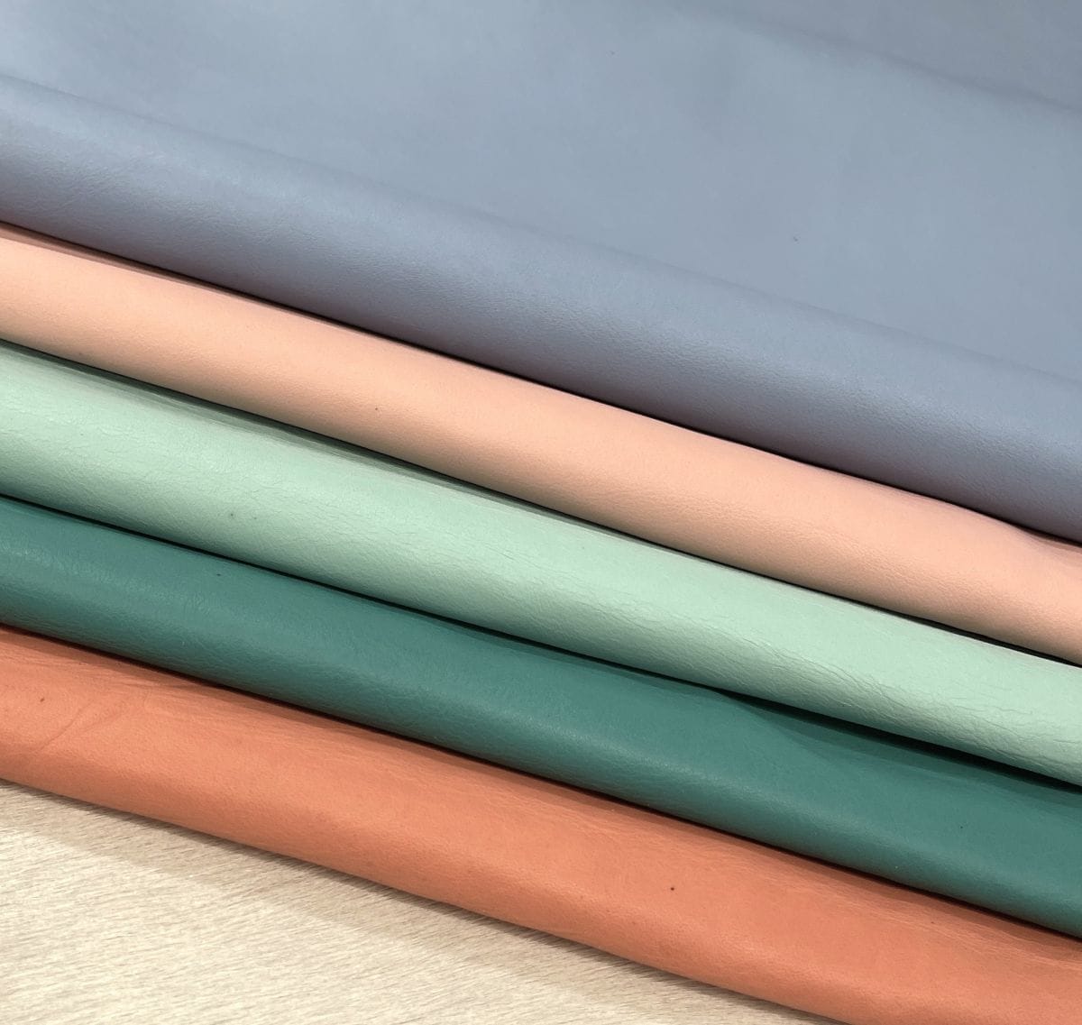 Craft grade leather half hides stacked in pastel colors
