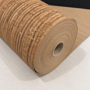 Rolled cork wallpaper or mat unrolled on a light surface, showing natural tan pattern and hollow cardboard core.