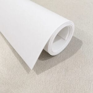 Rolled sheet of white paper partially unrolled on a brushed metal surface, blank and clean-looking.