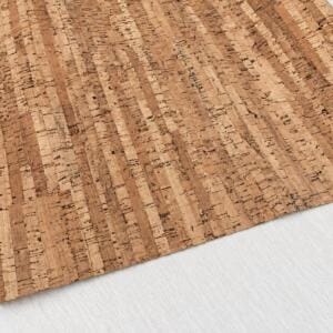 Close-up of cork flooring planks laid on a light gray floor surface.