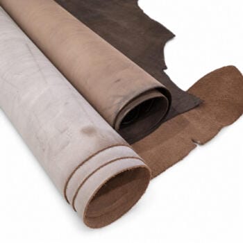 Pegasus waxed cow leather hides rolled, showing cut edges and suede backing in coffee brown and tan — genuine cowhide