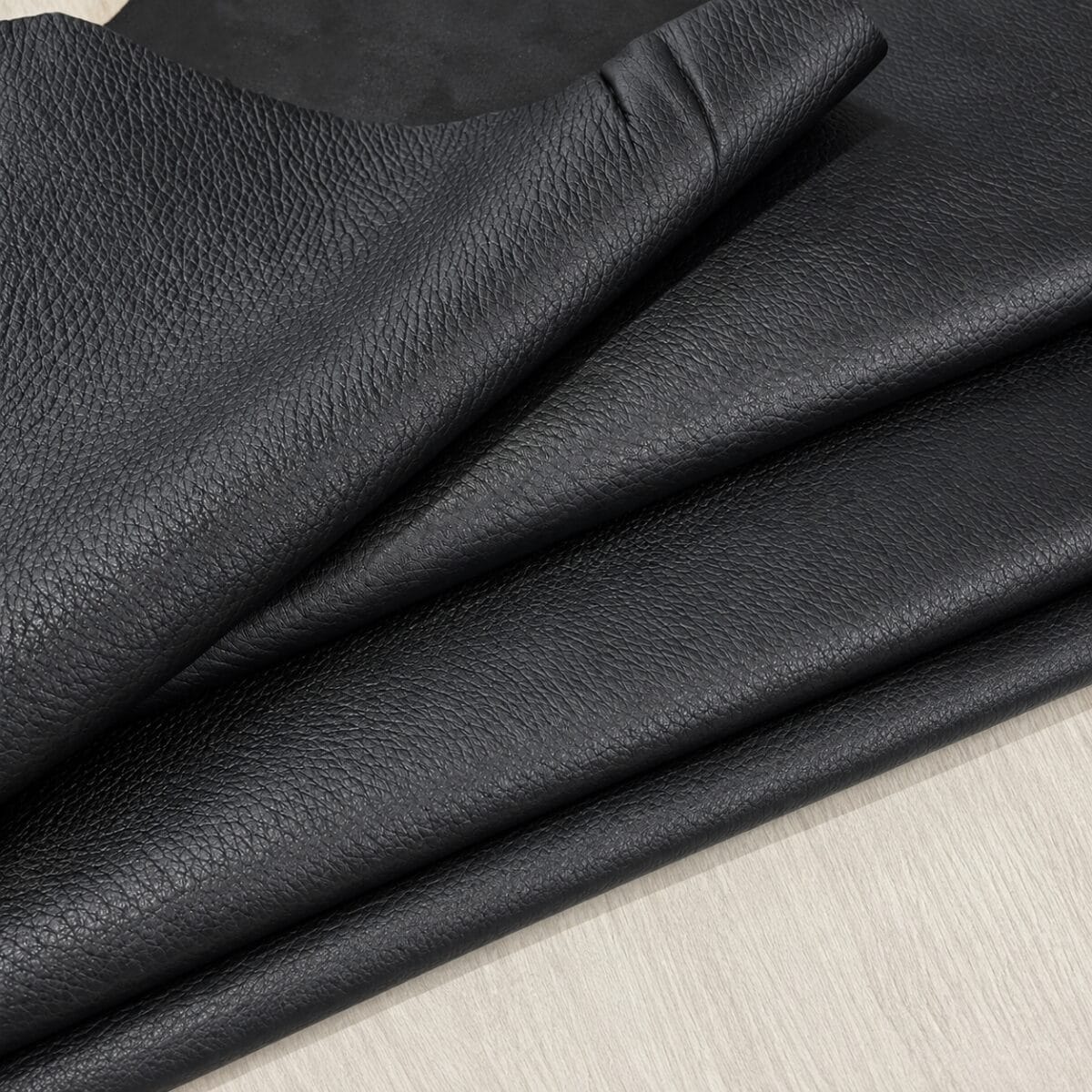 Black Pebble Lambskin Leather Floater folded Black pebble lambskin leather folded, showing the grain side and suede back