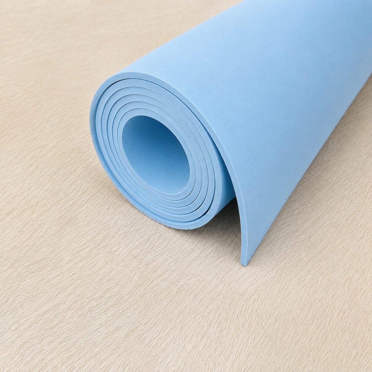 SP1253.B.BLUE.35.40- 4MM Rolled blue yoga mat resting on a light wooden floor