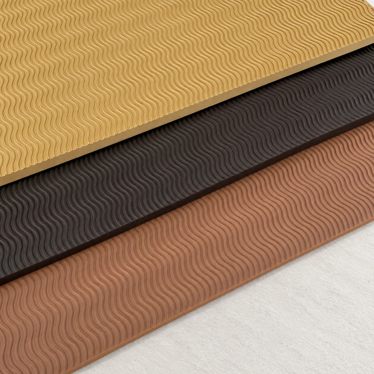 three overlapping wavy tread sheets Stack of textured rubber stair treads in beige, dark brown, and terracotta with a wavy pattern showing alternating layers.